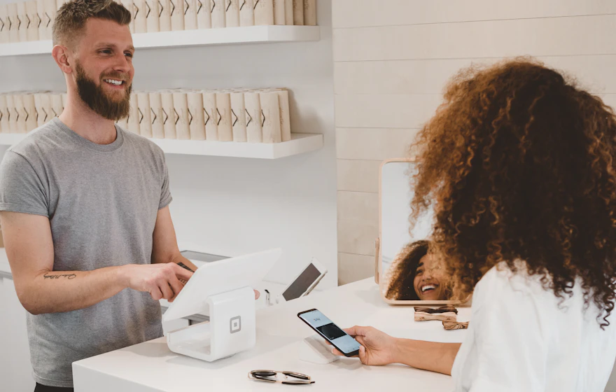 Customer paying by contactless phone at a retail checkout terminal