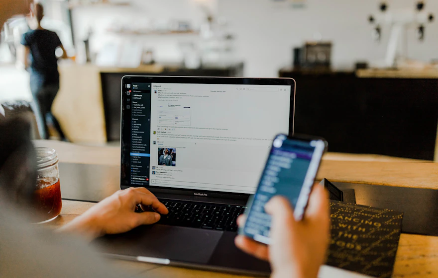 Support consultant working across a laptop and mobile phone