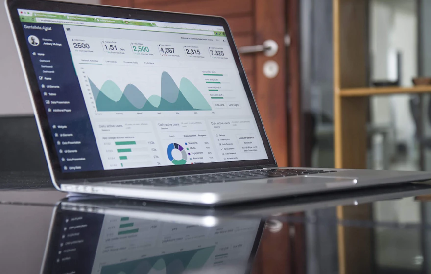 Laptop displaying a web application dashboard with charts and user metrics